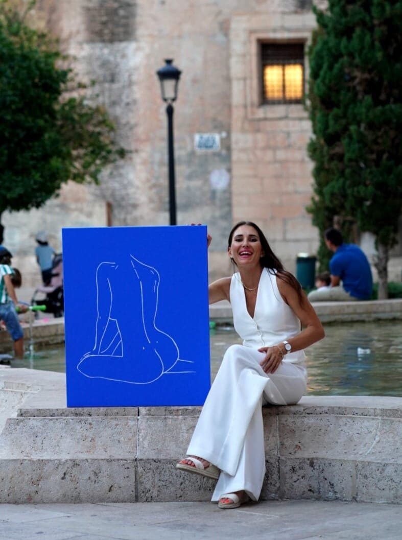Paula de Motta with a Women painting in a plaza at golden hour