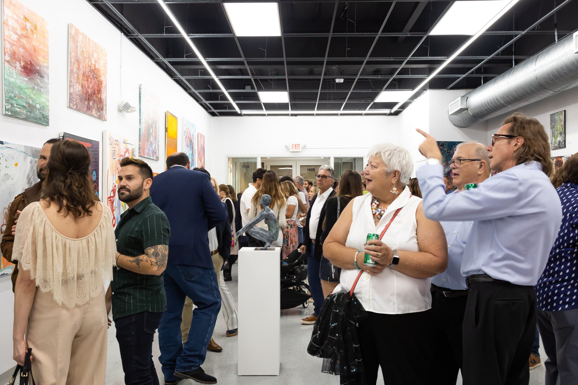 Visitors engaging with works by Paula de Motta during an exhibition